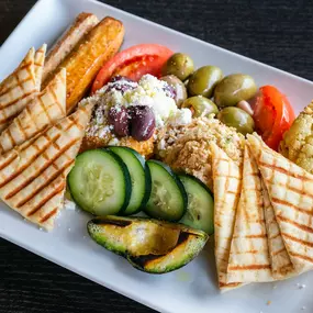 An assortment of veggies, hummus and gouda cheese dip served with pita bread.