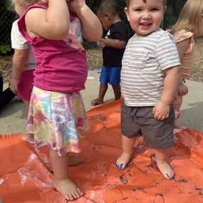 A sensory experience! Children use their feet to explore colors and textures, creating fun and vibrant foot art.