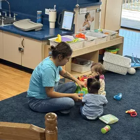 Playtime is learning time! Teachers and kids bond over toys, sparking creativity and problem-solving together.