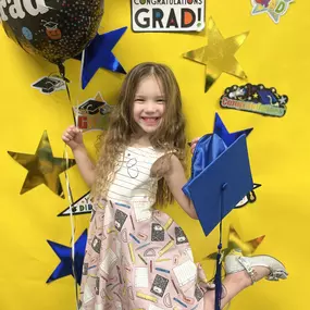 A moment to shine! This graduation pose marks a milestone and celebrates learning with a proud smile.