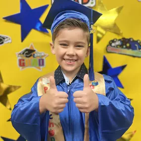 Graduation day joy! Another proud moment as a child celebrates a fun milestone with a beaming smile.