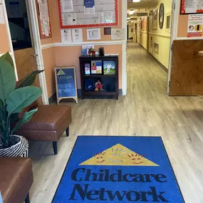 A cozy and inviting lobby, complete with comfortable seating and a colorful bulletin board showcasing heartwarming moments from our daycare. It’s the perfect space for families to feel welcomed and connected.