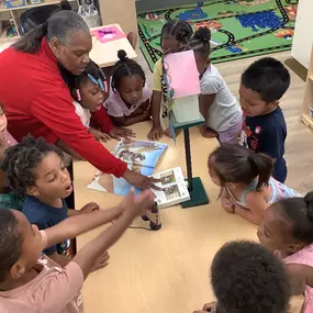 Fostering creativity! The teacher lends a hand as children explore new materials and techniques in their art projects.