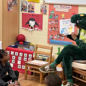 Storytime with a roar! The teacher, dressed as a dinosaur, brings stories to life and captures children’s imaginations.