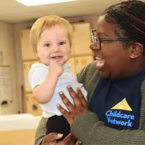 A caring teacher engaging with a child in the classroom, providing guidance and support during learning activities.