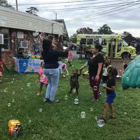 Children having a blast outdoors, chasing and popping bubbles in a fun and interactive bubble party.