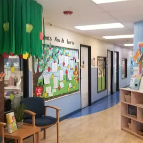 A cozy and inviting lobby, complete with comfortable seating and a colorful bulletin board showcasing heartwarming moments from our daycare. It’s the perfect space for families to feel welcomed and connected.