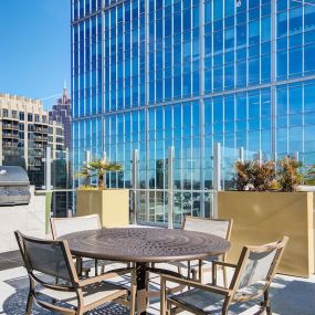 Rooftop lounge with views of midtown and table seating.