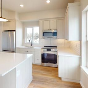Modern style kitchen with plank flooring, kitchen island with pendant lighting, double door refrigerator, cream wood style cabinets, and recessed lighting above