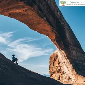 Mensch unter Natursteinbogen