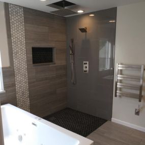 This bathroom project is from a few years ago. The shower is a zero-threshold design. I really like how the two different tile choices compliment each other. Also, the electric towel warmer on the right is a great addition! Are you looking for a unique design. See what we can do at our website.