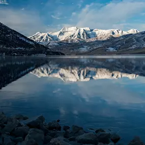 Mt. Timpanogos reflects in the water of Deer Creek Reservoir near new construction in Heber City, UT