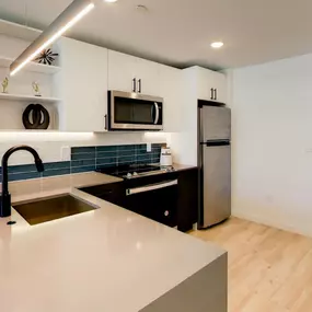 The kitchen at The Gio presents a sleek, contemporary design with a minimalist aesthetic and high-quality appliances.