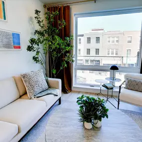 A stylish and inviting living room at The Gio offers ample natural light and modern furnishings.
