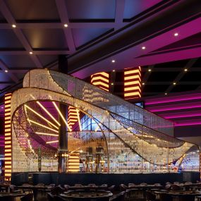 The Glass Bar at Planet Hollywood in Las Vegas offers edgy ombre lighting, ebony-stained wood, opulent brass, and gold-hued marble envelope you in a comfortable, yet elegant lounge experience.