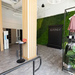 The lobby of KINRGY Studios WeHo, showing retail racks and the plant wall.