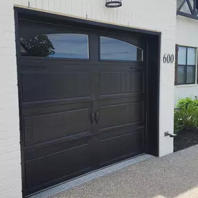 Here is a black single car carriage style garage door with arched windows that we recently installed.