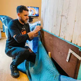 A team member disassembles a piece of furniture with care and precision.