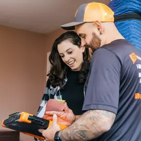 A CT Moving and Storage team member goes over moving paperwork with a smiling customer.