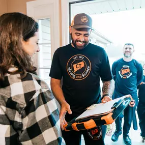 A CT Moving and Storage team member shares a smile with a customer while reviewing paperwork.