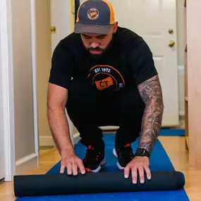 A mover rolls out floor protection before beginning work inside a customer’s home.