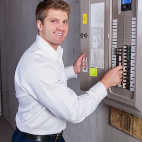 Electrician Testing A New Electrical Circuit Breaker Panel After Installation