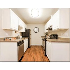 Kitchen with appliances, wood floors, cabinets and counter space