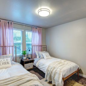 Bedroom with two twin beds and a large window.