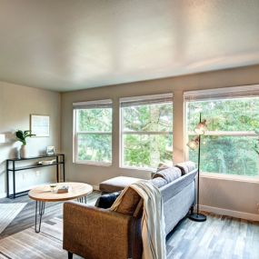 Living room with a fireplace, a wall of windows, and a couch.