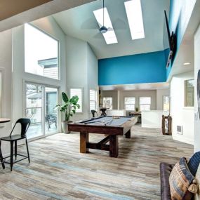 Game room at The Lynx with skylights and a pool table, smaller tables and chairs.