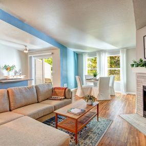 A living room with a couch, coffee table, and fireplace.