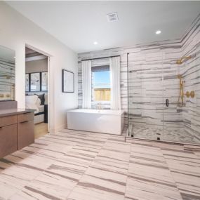Spa-like primary bathrooms with large walk-in showers, free-standing bathtub, and dual vanities with undermount sinks