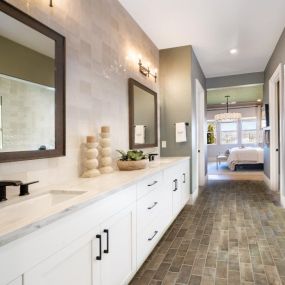 Luxurious primary bathrooms with dual sink vanity, undermount sinks, and large walk-in shower with tile surround
