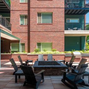 Red brick outdoor patio with chairs surrounding a fire pit