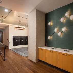 Spacious walkway to the mail area with chic wall decorations on the green wall and modern style chandelier