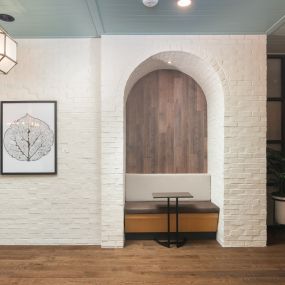 Private arched brick study area with small table and seating