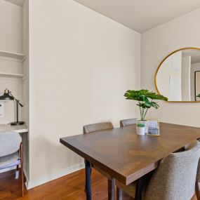 Chic seperate dining room with a patterned wood table next to a small built-in desk with wall shelving and a grey chair