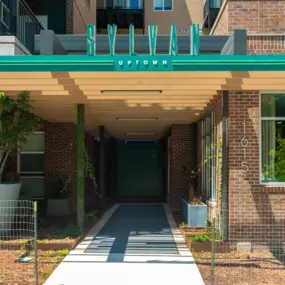 the red brick entrance to the property with a green awning