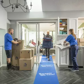 Crew members packing a home and moving a chair