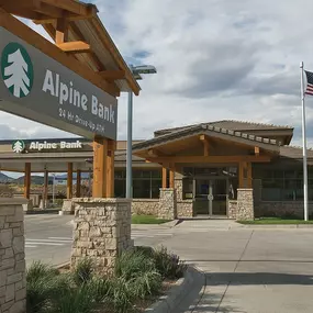 Showcasing Mappco Construction's excellence, this photo features the Alpine Bank building, an example of commercial architecture. The structure is distinguished by its rustic stone and wood elements, with a 24-hour drive-up ATM service advertised under a timber-framed sign, reflecting Mappco’s commitment to blending functionality with aesthetic appeal in business construction.