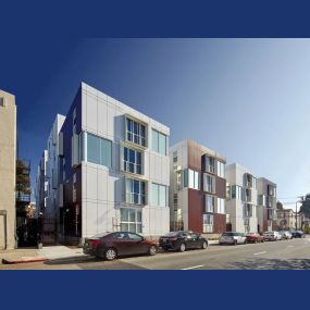 Street view of Garden Village Apartments four-story building with large windows.