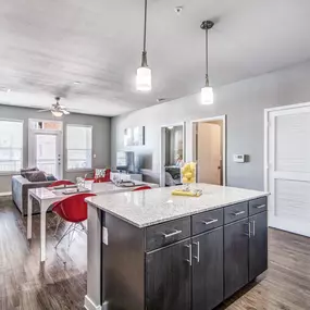 The kitchen with an island and a dining room in the background