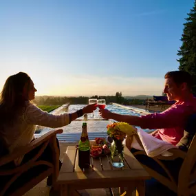 Two customers enjoy glasses of wine by the side of their new Water's Edge pool