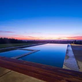 A sunset across a beautiful pool constructed by Water's Edge Pools & Spas