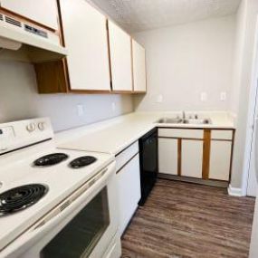 a kitchen with white cabinets and a black dishwasher