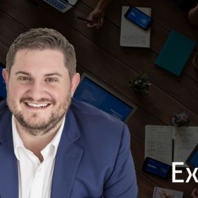 Alex Klingelhoeffer smiles in a business suit, a Wealth Advisor at the Oklahoma City branch of Exencial Wealth Advisors.