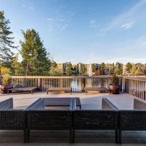 a deck with a fire pit and a view of the lake at Ashford Belmar Apartments, Colorado