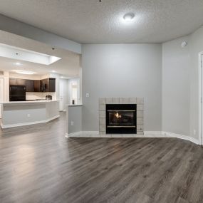 living room with a fireplace and a kitchen at Ashford Belmar Apartments, Lakewood, Colorado