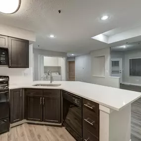 a kitchen with a white counter top and black appliances at Ashford Belmar Apartments, Lakewood