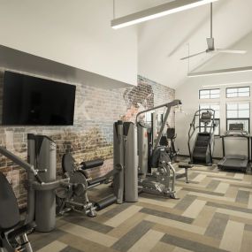 Fitness center with multiple cardio machines and free weights.